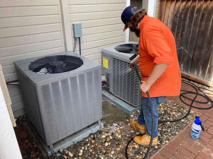 Barker technician servicing an air conditioner condenser