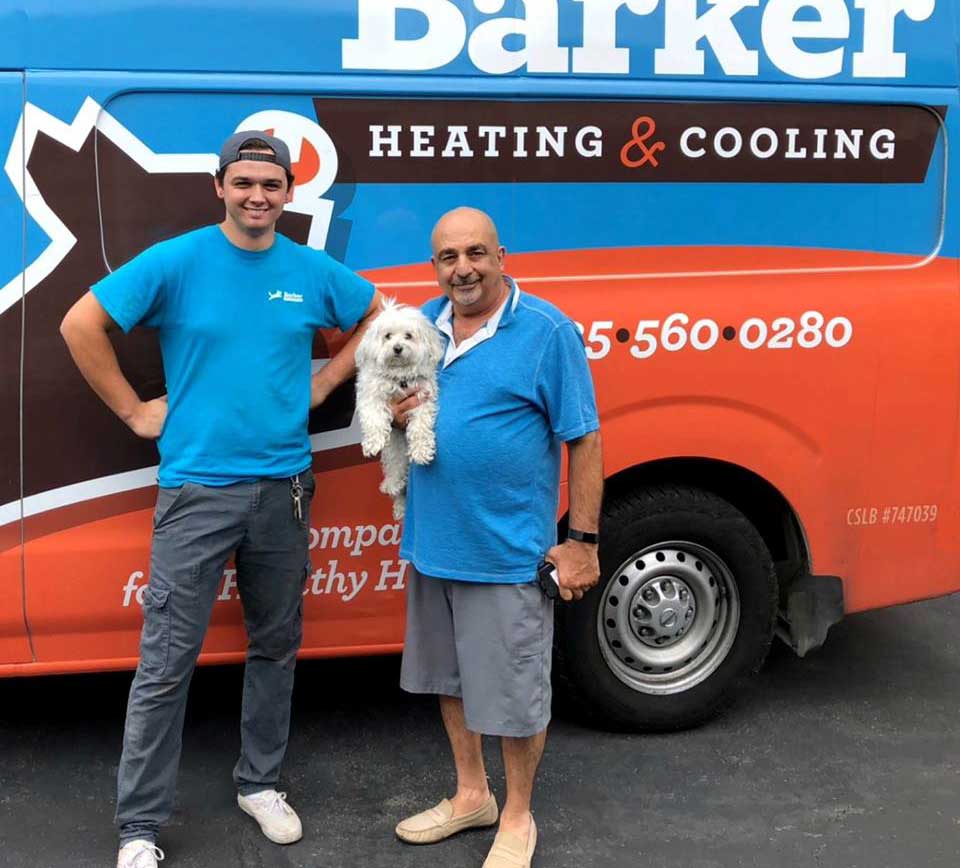Barker team members and a four-legged friend in front of the Barker van