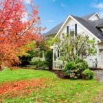Residential house with garden showcasing vibrant autumn foliage and lush greenery, perfect for HVAC maintenance tips.